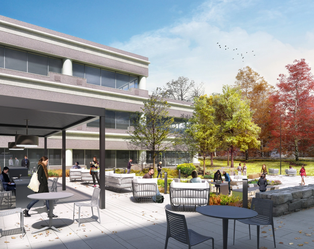 Outdoor workspace with patio furniture, landscaped greenery, and autumn-colored trees in background